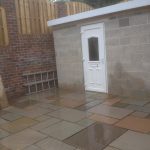 Paving and small outbuilding with breeze blocks and uPVC door